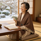 和室で読書をしながらヒートショールを羽織るシニア女性